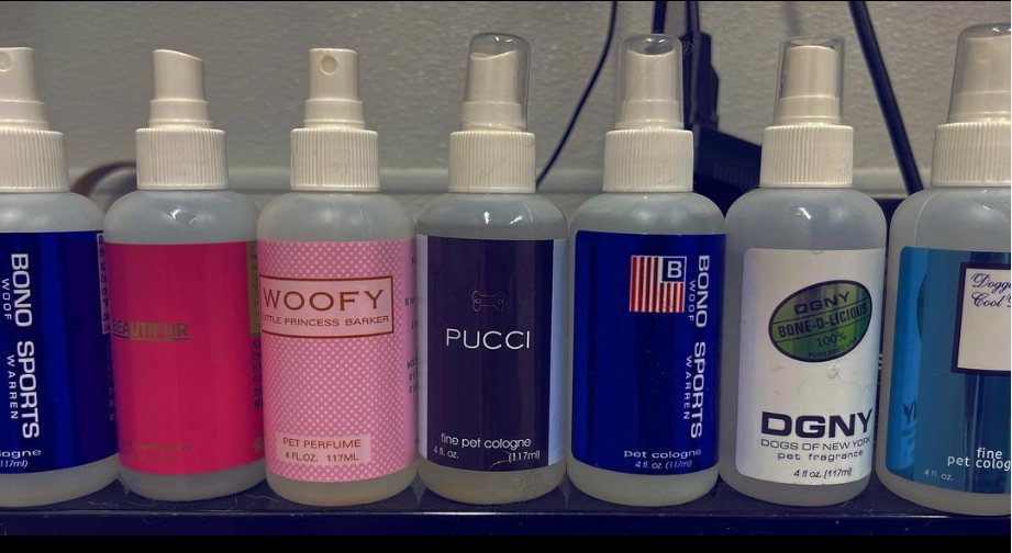 Row of designer-style pet perfume and cologne spray bottles used at Golden Paw Spa